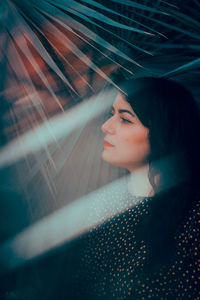 Portrait of woman looking through window