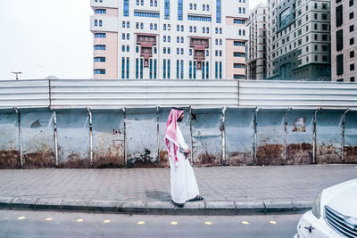 Midsection of woman with umbrella in city