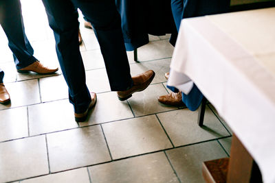 Low section of people walking on tiled floor