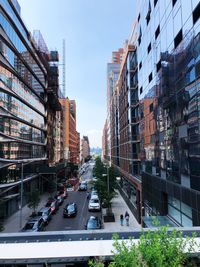 Traffic on city street by buildings against sky