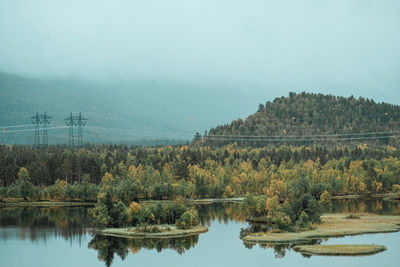 Scenic view of lake by trees against sky