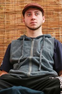 Portrait of young man standing against brick wall