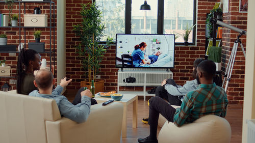 Rear view of people sitting on table