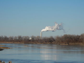 Smoke emitting from trees against clear sky