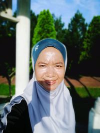 Portrait of woman in hijab against trees