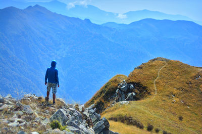 Rear view of man looking at mountain landscape