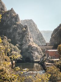 Scenic view of river by mountains against clear sky