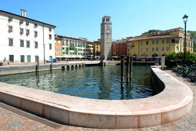 View of buildings by canal against clear sky