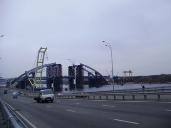 Cars on road in city against sky