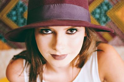 Close-up portrait of beautiful young woman wearing hat