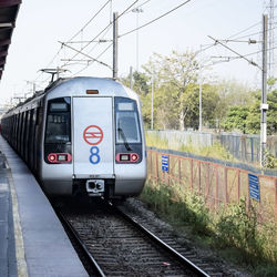 Delhi metro train arriving at jhandewalan metro station in new delhi, india, public metro departing