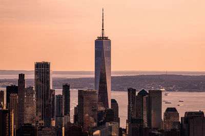 Modern buildings in city against sky during sunset