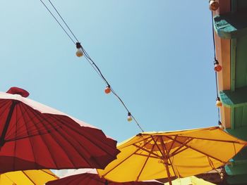 Low angle view of string light on parasol against sky