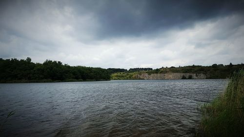 Calm lake with trees in background