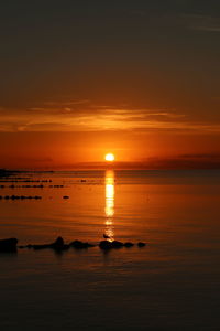 Scenic view of sea against orange sky