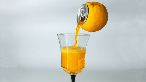 Digital composite image of orange pouring drink in glass