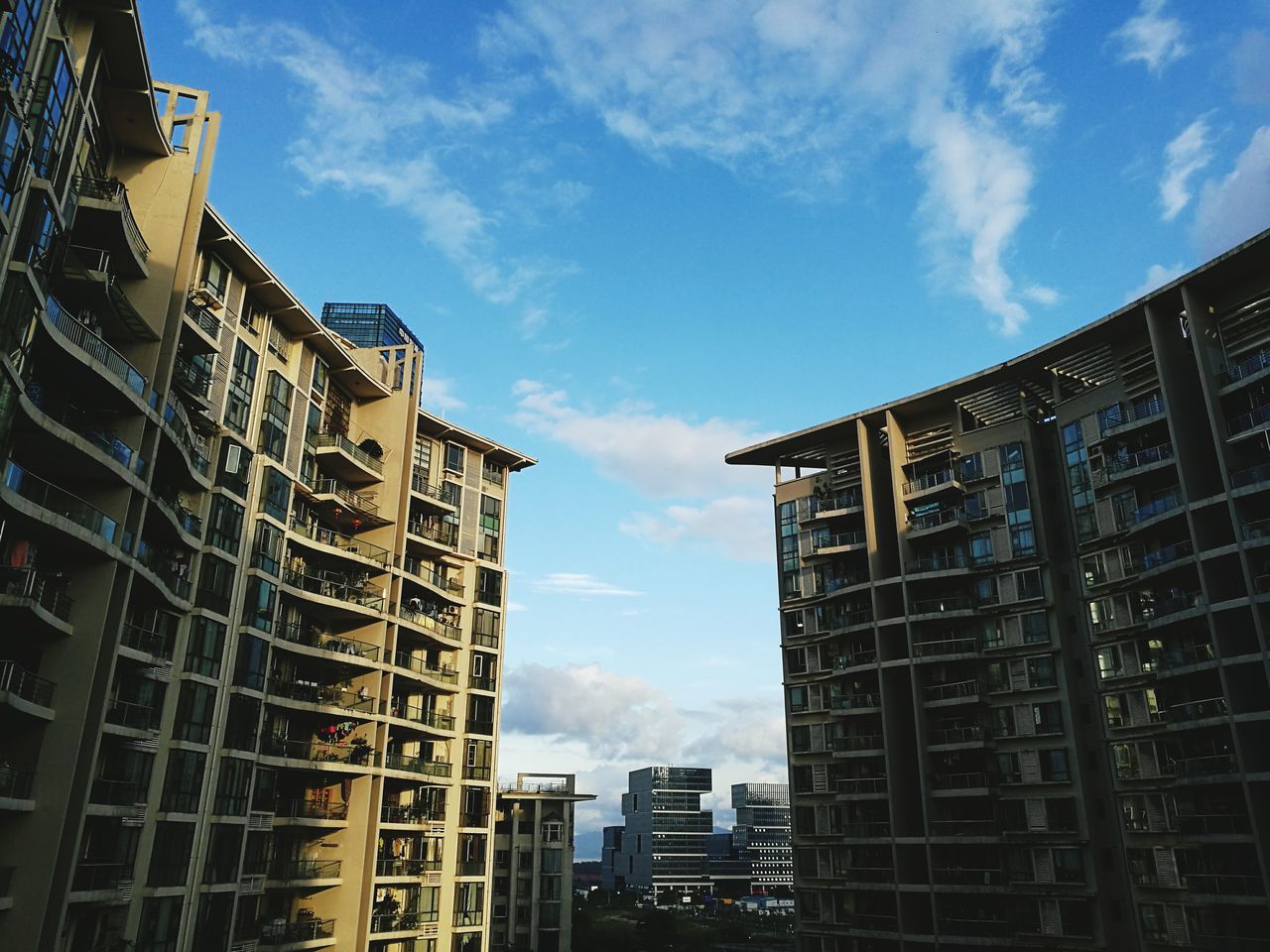 architecture, building exterior, built structure, city, sky, low angle view, skyscraper, tall - high, building story, tower, modern, city life, office building, development, urban skyline, cloud - sky, travel destinations, blue, spire, outdoors, day, financial district, tall, skyline, no people