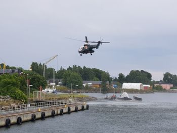 Airplane flying over river against sky