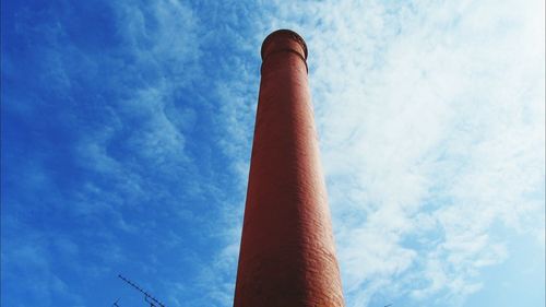 Low angle view of smoke stack against cloudy sky