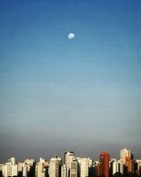 Buildings in city against blue sky