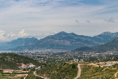 Aerial view of townscape and mountains against sky