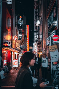 People on illuminated city street at night