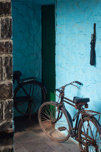 Bicycle against blue wall of building