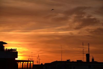 Low angle view of silhouette buildings against dramatic sky