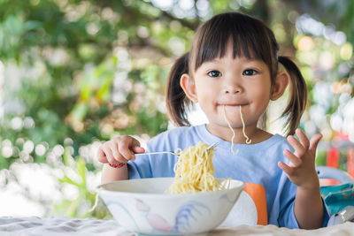 Portrait of cute girl sitting outdoors