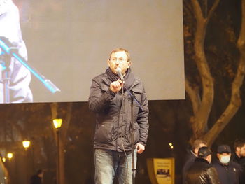 People standing on illuminated street at night