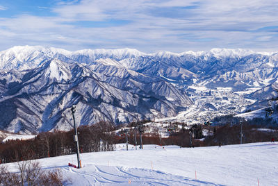 Snow covered trees and mountains against sky