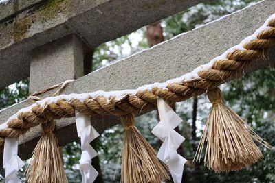 Close-up of straw festoon hanging on stone gate