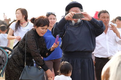 Rear view of people holding mobile phone