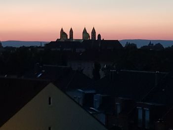 Silhouette of buildings in town at sunset