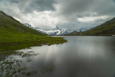 Scenic view of mountains and lake against cloudy sky