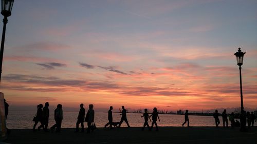 Silhouette people on beach during sunset