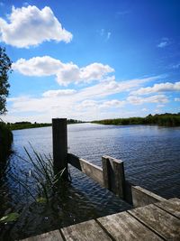 Pier over lake against blue sky