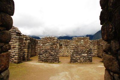 Old stone walls at machu picchu in foggy weather