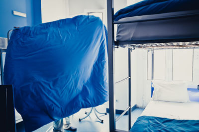 Low section of man holding blanket in hostel room