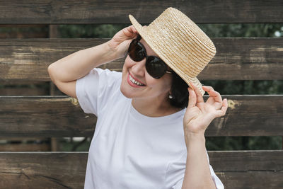 Portrait of young woman wearing sunglasses on wood