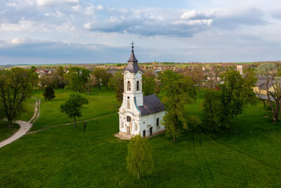 Aerial view about abandoned chapel next to cziraky castle with cloudy sky at the background.