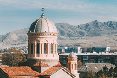 Church by buildings against sky in city