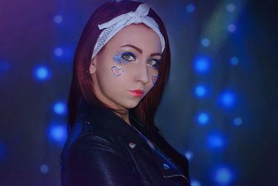 Portrait of young woman with arms raised