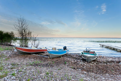 Boats moored on shore against sky