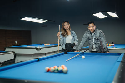 Portrait of woman playing pool