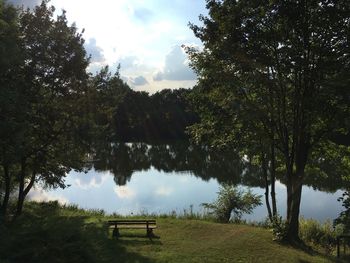 Trees by lake against sky