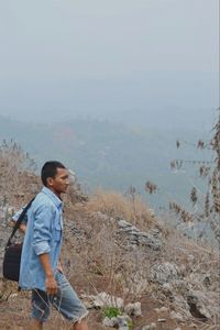 Side view of man looking at mountains