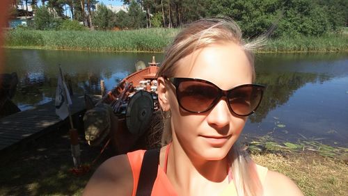 Portrait of woman wearing sunglasses at lake