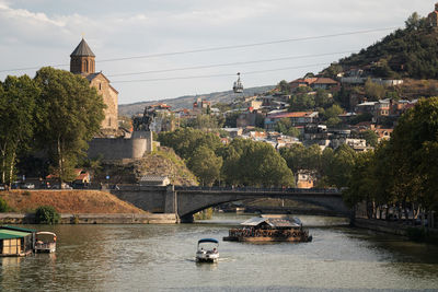 Bridge over river against buildings in city