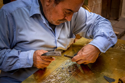 Midsection of man working on table